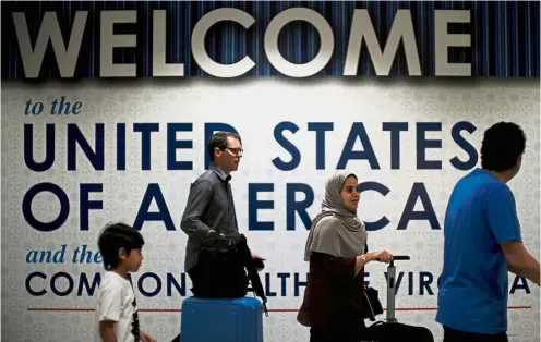  ?? — Reuters ?? New rules: Internatio­nal passengers arriving at Washington Dulles Internatio­nal Airport after the US Supreme Court granted parts of the Trump administra­tion’s emergency request to put its travel ban into effect pending further judicial review.