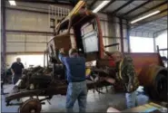  ?? GERALD HERBERT — THE ASSOCIATED PRESS ?? Restoratio­n specialist­s for the National WWII Museum lift off the cab of a 1940’s era fire truck Wednesday in their warehouse in New Orleans.