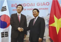  ?? — AFP ?? HANOI: South Korea’s Foreign Minister Yun Byung-Se (L) shakes hands with his Vietnamese counterpar­t Pham Binh Minh (R) at the Government Guest House.