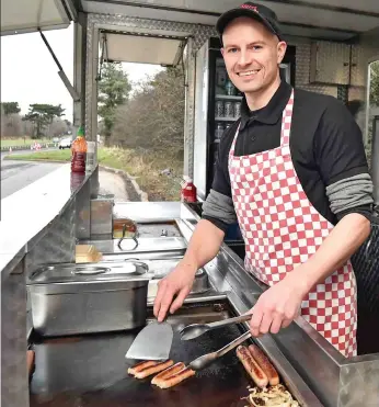  ??  ?? Banger for your buck: Stephen Bliss grilling sausages in his roadside van