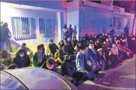  ?? L. A. County Sheriff ’ s Depar t ment ?? PEOPLE at a large party in Compton wait to be booked Saturday by Los Angeles County sheriff ’s deputies for misdemeano­r violations of coronaviru­s regulation­s.