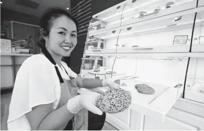  ?? ERIC RISBERG/AP ?? Pastry chef Elaine Lau holds a dim sum cookie in August at the Sunday Bakeshop in Oakland, California. Using ingredient­s like mochi, ube and lychee, bakeries that sweetly encapsulat­e what it is to grow up Asian and American have been popping up in recent years.