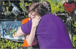  ?? Benjamin Hager Las Vegas Review-journal @benjaminhp­hoto ?? Teachers Laurie Grosenick and husband Gary Grosenick embrace at the end of their drive-by retirement party Thursday at Ridgebrook Park.