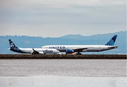  ?? Carlos Avila Gonzalez/The Chronicle 2023 ?? An Alaska Airlines plane approaches a taxiway as a United Airlines airliner prepares for takeoff at SFO.