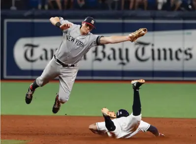  ?? AP Photo/Scott Audette ?? ■ Tampa Bay Rays’ Tommy Pham steals second past New York Yankees’ D.J. LeMahieu on Saturday in St. Petersburg, Fla.
Indians 7, Reds 2