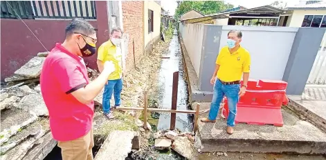  ?? ?? (From left) Goh briefs Dr Sim and Lim on the drainage project issue affecting Lorong 14 of RPR Batu Kawa in Kuching.