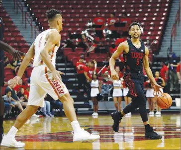  ?? STEVE MARCUS ?? Noah Robotham, right, brings the ball upcourt during the UNLV basketball Scarlet & Gray Showcase in October at the Thomas & Mack Center. Robotham, who transferre­d from Akron and must sit out games this season, has been learning coach Marvin Menzies’...