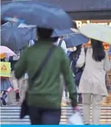  ?? . — AFP ?? TOKYO: People cross a street in Tokyo’s Ginza district yesterday