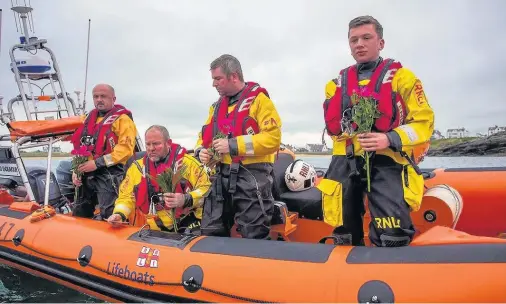  ??  ?? Trearddur Bay RNLI crew laying the flowers and a photograph in memory of Amy Gillat in the bay