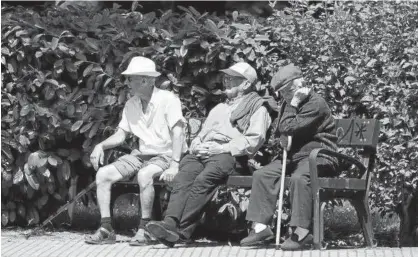  ?? Foto: Aritz García ?? Tres ancianos descansan del calor estival en un banco de Vitoria.