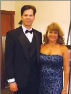  ??  ?? Event chairmen Deborah and Scott Clark stand in front of donated art at the annual Wine and Roses Gala at the Reynolds Cancer Support House in Fort Smith.