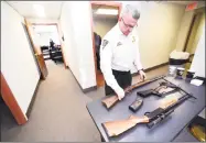  ?? Arnold Gold / Hearst Connecticu­t Media ?? New Haven Police Academy Commander Rob Criscuolo examines rifles brought in for a gun buy-back at the New Haven Police Academy on Saturday.