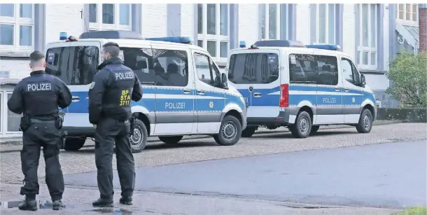  ?? FOTO: GIANNI GATTUS/DPA ?? Polizeibea­mte stehen am Mittwoch während der Razzia vor einem Gebäude in Solingen.