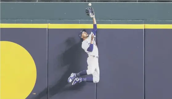  ??  ?? 0 Mookie Betts of the Los Angeles Dodgers catches a fly ball at the wall hit by the Atlanta Braves’ Freddie Freeman to prevent a home run.