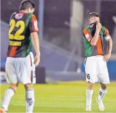  ?? FOTO: AP ?? Matías Escudero y Leonardo Valencia se cubren el rostro, afectados por las lacrimógen­as.