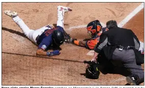  ?? (AP/Jim Mone) ?? Home plate umpire Manny Gonzalez watches as Minnesota’s Luis Arraez (left) is tagged out by Houston catcher Martin Maldonado as he attempted to score on a Marwin Gonzalez single in the fifth inning of Wednesday’s Game 2 of their American League wild-card series at Target Field in Minneapoli­s. Houston won the game 3-1 to sweep the series and handed Minnesota its 18th consecutiv­e postseason loss.