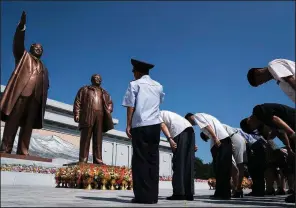  ?? AP/ANDREW HARNIK ?? North Koreans pay their respects Saturday in front of statues of late leaders Kim Il Sung (left) and Kim Jong Il in Pyongyang. The country will mark the anniversar­y of Kim Il Sung’s death today.
