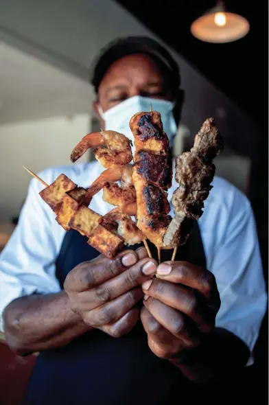  ?? ARIEL COBBERT/ THE COMMERCIAL APPEAL ?? Owner Ermyias Shiberou poses with a chicken, shrimp, steak and tofu kabobs at Stickem restaurant on Madison Avenue in Memphis.