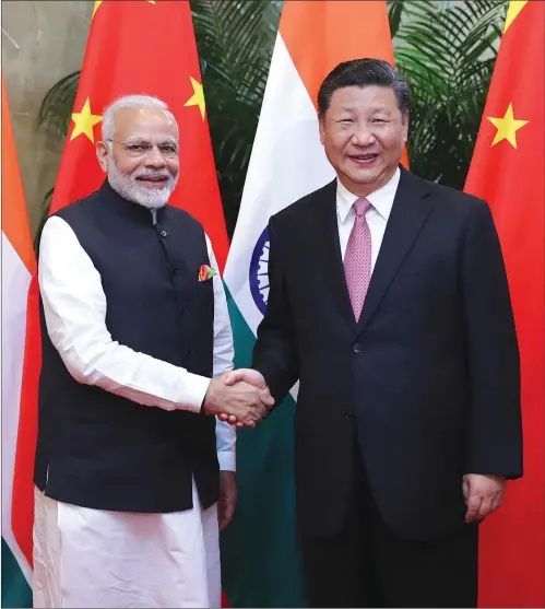  ?? Photo: Xinhua ?? Chinese President Xi Jinping (right) welcomes visiting Indian Prime Minister Narendra Modi in Wuhan, capital of Central China’s Hubei Province, on Friday.