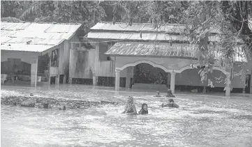  ??  ?? Villager at Kampung Rahmat, Rantau Panjang wading through flood waters in their village. — Bernama photo