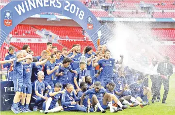  ??  ?? Conte sprays champagne over his celebratin­g players after their win in the English FA Cup final football match between Chelsea and Manchester United at Wembley stadium in London. — AFP photo
