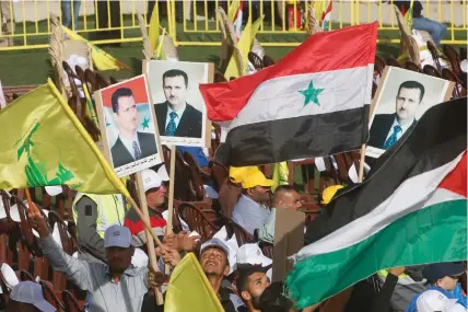  ?? (Aziz Taher/Reuters) ?? SUPPORTERS OF Hezbollah leader Hassan Nasrallah wave flags and pictures of Syrian President Bashar Assad during a rally marking al-Quds Day in Maroun Al-Ras, near the Israeli border in southern Lebanon, on June 8, 2018.