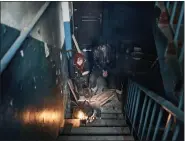  ?? LIBKOS - THE ASSOCIATED PRESS ?? Residents cook on the stairs of an apartment house in Chasiv Yar, Donetsk region, Ukraine, on Monday.