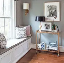  ?? ANGIE SECKINGER/ SHERRY MOELLER VIA AP ?? A bar cart placed near a comfortabl­e window seat provides a place for a reading lamp and a spot to rest a mug or glass, creating a cozy reading nook with plenty of natural light.