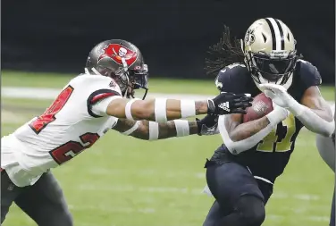  ?? Associated Press ?? Breaking free: New Orleans Saints running back Alvin Kamara, right, runs against Tampa Bay Buccaneers cornerback Carlton Davis during the first half of an NFL divisional round playoff football game Sunday in New Orleans.