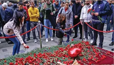  ?? (AFP) ?? People lay flowers at a makeshift memorial for the victims of Sunday’s explosion at the busy shopping street of Istiklal in Istanbul on Monday