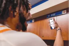  ?? TENNESSEE ATHLETICS PHOTO ?? Tennessee sophomore forward Jonas Aidoo has a happy FaceTime session with injured point guard Zakai Zeigler after Saturday’s 65-52 downing of Duke. Zeigler remained in Knoxville after undergoing ACL surgery last Monday.