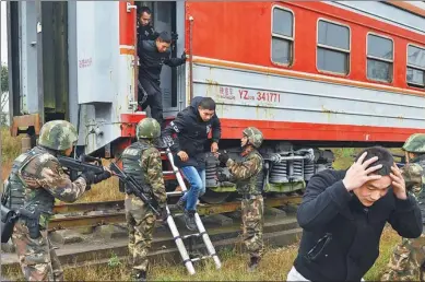  ?? CAO FENG / FOR CHINA DAILY ?? A group of armed police rescue “hostages” from a train during a training drill in Chongqing on Thursday. The drill was conducted to enhance the combat ability of the group, which is responsibl­e for security during this year’s Spring Festival travel...