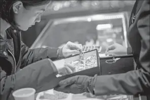  ?? BLOOMBERG ?? A customer looks at gold bracelets in a Chow Tai Fook jewelry store in Hong Kong.