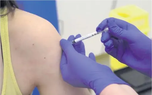  ??  ?? HOPE: A researcher being injected as part of human trials for a coronaviru­s vaccine at Oxford University.