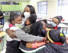  ?? MIKE HASKEY/LEDGER-ENQUIRER VIA AP ?? Shameika Averett, founder of Gigi’s PEARLS Inc., hugs students at Dorothy Height Elementary School on Jan. 14, 2021, in Columbus, Ga., after he first meeting of Gigi’s PEARLS.