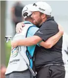  ?? GREG BARTRAM, USA TODAY SPORTS ?? Irishman Shane Lowry gets a hug from caddie Dermot Byrne after earning his first PGA Tour win in 28 events, the Bridgeston­e Invitation­al.