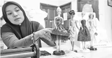  ??  ?? Erpha Ahdayani showing her silk and cotton Silkstone Barbie gown collection. - Bernama photo