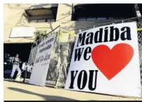 ??  ?? > Imagen que muestra una pancarta con un mensaje de apoyo para el expresiden­te sudafrican­o Nelson Mandela, a las puertas del hospital en Pretoria (Sudáfrica).