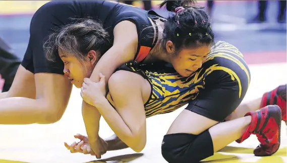  ?? DAN JANISSE ?? Jessica Hong, bottom, of Sir Robert Borden High School, and Kaleigh Prieur of Riverside Secondary School wrestle during their OFSAA match on Wednesday at the WFCU Centre.