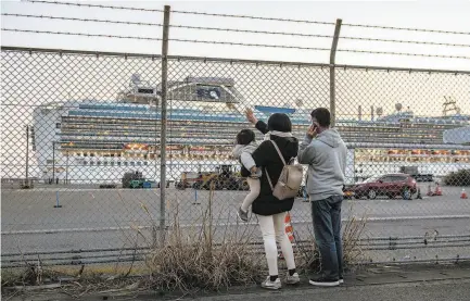  ?? Carl Court / Getty Images ?? People wave to family aboard the Diamond Princess cruise ship, which is quarantine­d at a dock in Yokohama, Japan.