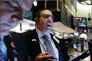  ?? AP/RICHARD DREW ?? Robert Oswald works Friday on the floor of the New York Stock Exchange, where stocks again put on an uneasy showing, capping a bumpy week.