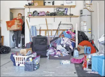  ?? Rachel Aston Las Vegas Review-Journal @rookie__rae ?? Aidan Swainston carries out a box at the former home of Kari Monson in 2018. Members of a local church helped Monson retrieve her belongings.