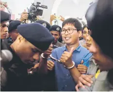  ??  ?? Wa Lone (centre) is escorted by police as he arrives for a court appearance in Yangon. — AFP photo