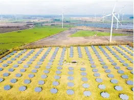  ?? AP ?? Solar panels stand on the edge of a wind farm in Sprakebuel­l, Germany, Thursday, March 14, 2024.