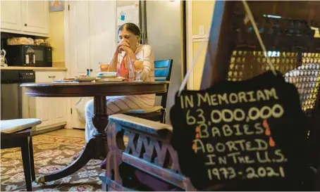  ?? DAVID GOLDMAN/AP ?? Tanya Britton prays before lunch last month in her kitchen in Tupelo, Miss., with a sign memorializ­ing aborted babies resting on a nearby chair.