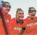 ?? ERIN TUDRYN/MARYLAND ATHLETICS ?? Sophomore defender Lily Grant, center, holding phone, has assumed the role of pregame hype specialist for the Maryland women’s lacrosse team. The Archbishop Spalding graduate and Pasadena native has been described as the“heart and soul”of the Terps.