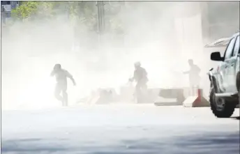  ?? AP PHOTO ?? Security forces run from the site of a suicide attack after the second bombing in Kabul, Afghanista­n. A co-ordinated double suicide bombing hit central Kabul on Monday morning.