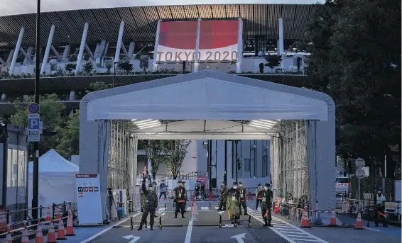  ?? PHOTO: GETTY IMAGES ?? Guarded . . . Soldiers wearing face masks guard an entrance to Tokyo Olympic stadium yesterday.