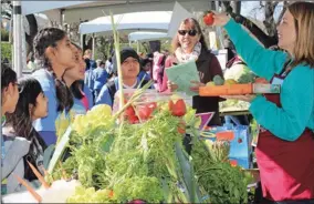  ?? PHOTO BY CHING LEE ?? Danielle Best of Certified Farmers’ Markets of Sacramento, right, talks about fresh strawberri­es with students from Sacramento-area elementary schools. A Farm Day event at the California Farm Bureau Federation in Sacramento included more than 1,500...