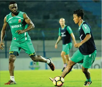  ?? A.YUSRON FARISANDY/JAWA POS RADAR MADURA ?? selengkapn­ya lihat grafis). PERSIAPAN: Bayu Gatra (kanan) dikawal Boubacar Sanogo dalam latihan Madura United di Gelora Bangkalan tadi malam (17/5).